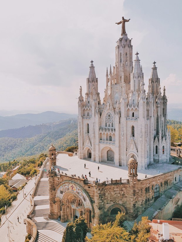 The white Gothic-style church on top of Tibidabo, with the wooded Collserola hills rolling away behind.